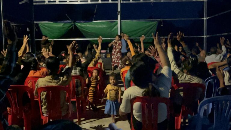 people raising their hands for salvation in cambodia